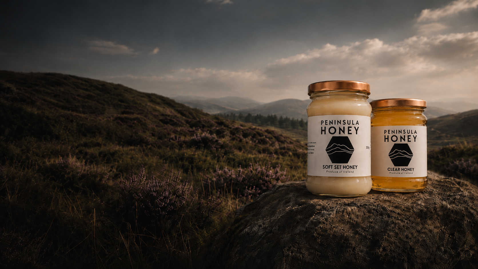 Two jars of Peninsula Honey on a rock in the Cooley Mountains at dusk